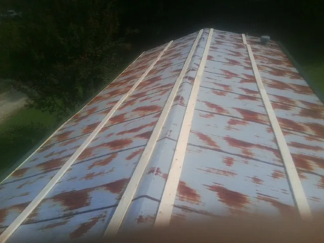 Rusted metal roof panels with new wood purlins before replacement — Storm Damage Roof Repair in La Vernia by Roofing Brothers