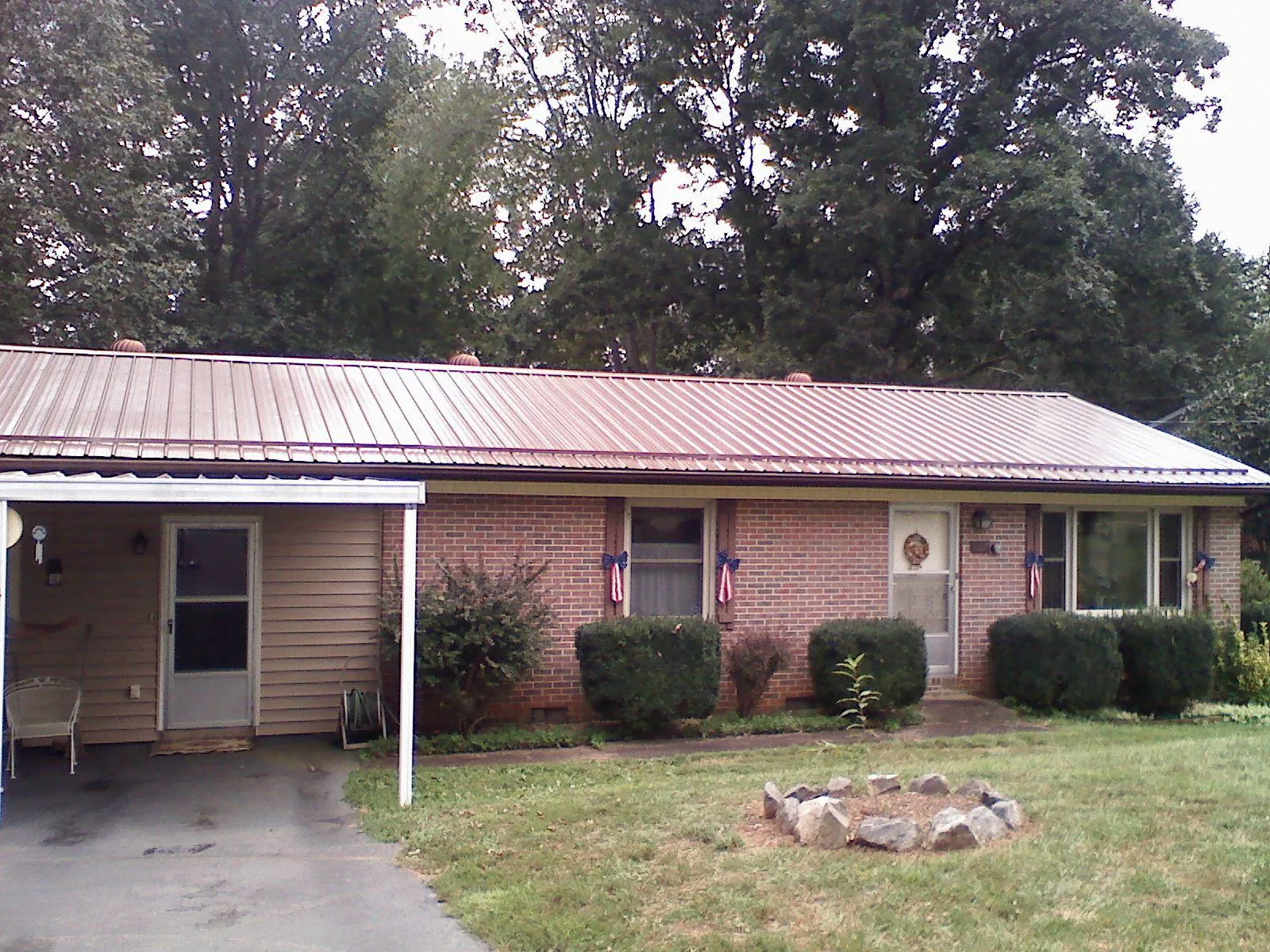 Bronze metal roof and carport on a brick ranch home — Roof Repair work by our crew in La Vernia